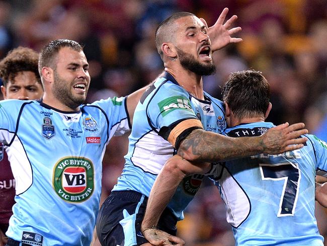 Mitchell Pearce of the Blues is congratulated by teammates after scoring a try.