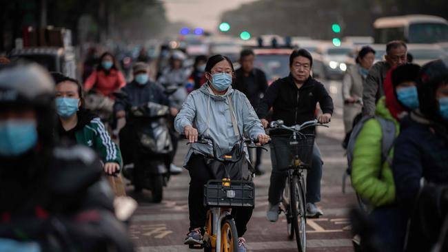 People wearing face masks as a preventive measure against the COVID-19 coronavirus commute during rush hour in Beijing. Picture: AFP