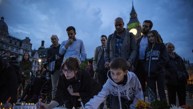 People sign messages of condolence for MP Jo Cox during a vigil in Parliament Square. Picture: Getty