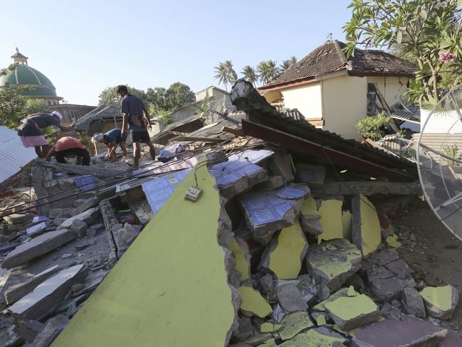 Villagers salvage usable items from homes destroyed in an earthquake in North Lombok. Picture: AP