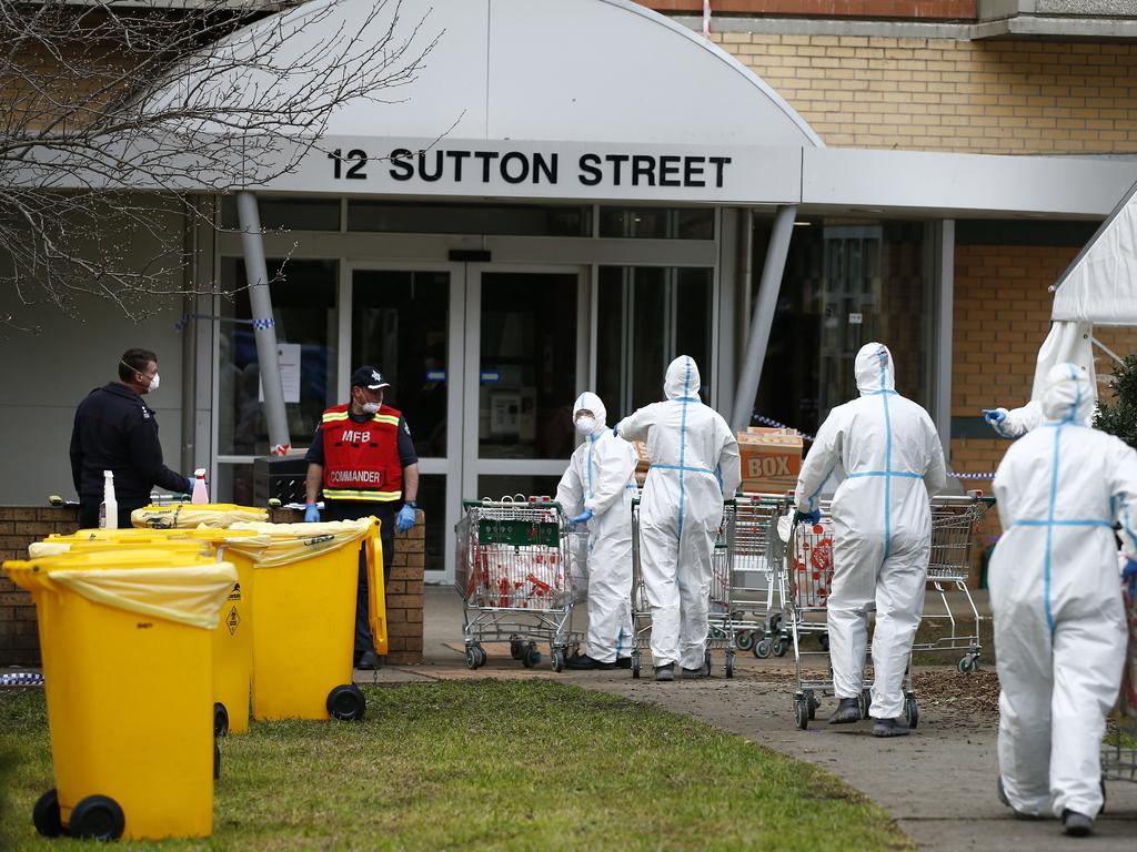 Workers in full body PPE deliver food into the locked down public housing towers in North Melbourne. Picture: Daniel Pockett