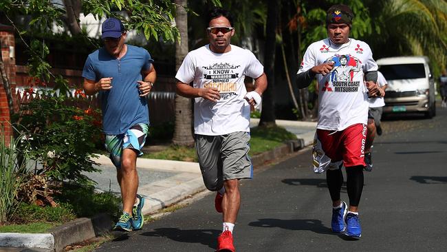 <i>The Australian</i>’s Brent Read, left, keeps up with Manny Pacquiao on his neighborhood run in Manila yesterday. Picture: Chris Hyde