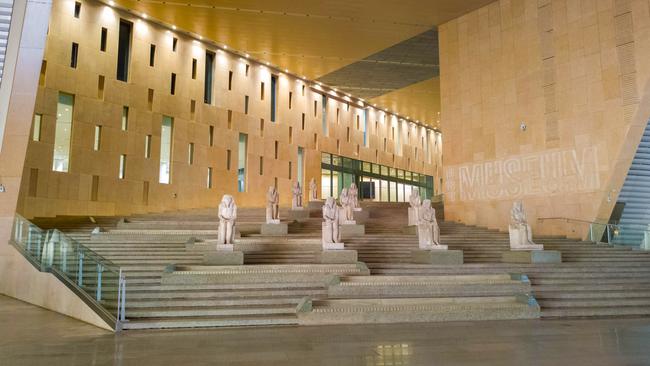 A central, four-level marble staircase is covered with thousands-years-old statues.