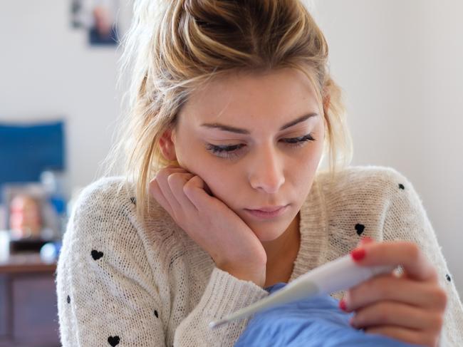 Sad young girl reading a pregnancy test result