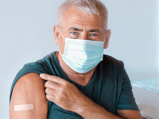 Male Senior in Face Mask after Receiving COVID-19 Vaccine. Elderly Man feeling Good on getting Coronavirus Vaccine. Covid Vaccination for Older People. Senior Patient showing Arm with Bandage, Patch. Picture: Istock