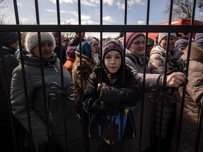 Residents wait for food outside a church in Trostianets. Picture: Fadel Senna/AFP