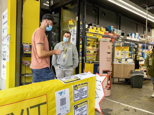 Customers show vaccination certificates to staff before entering JB HIFI in South Yarra. Picture: NCA NewsWire / David Geraghty