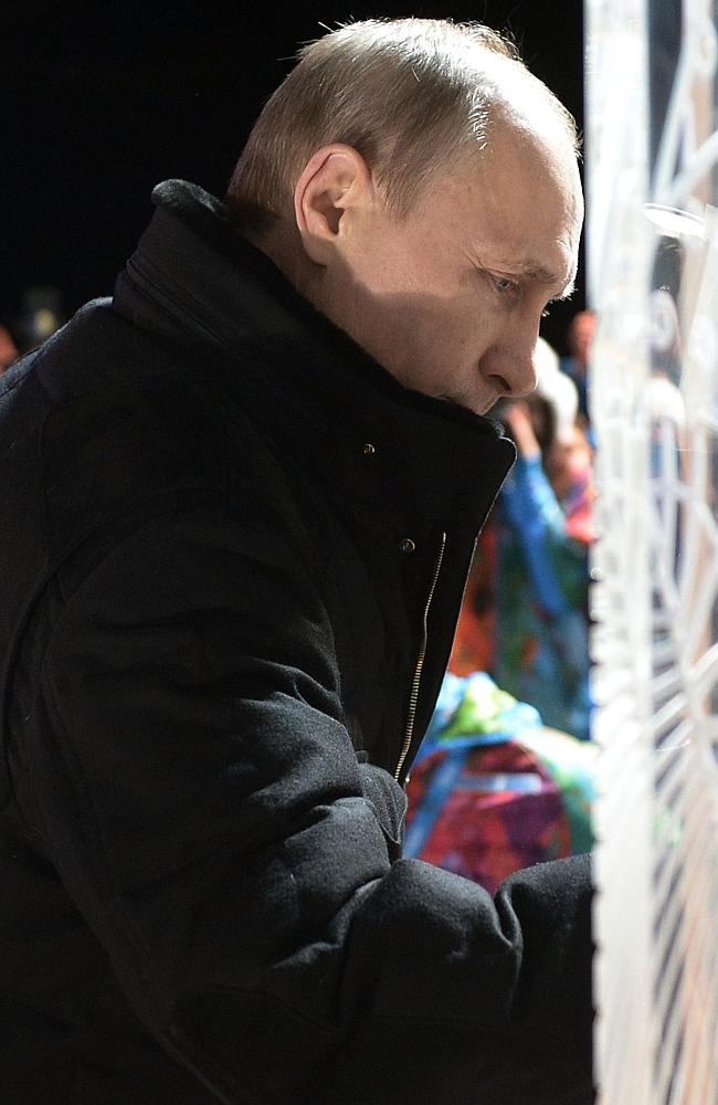 Putin signs a board in the Paralympic village ahead of the opening of the games.