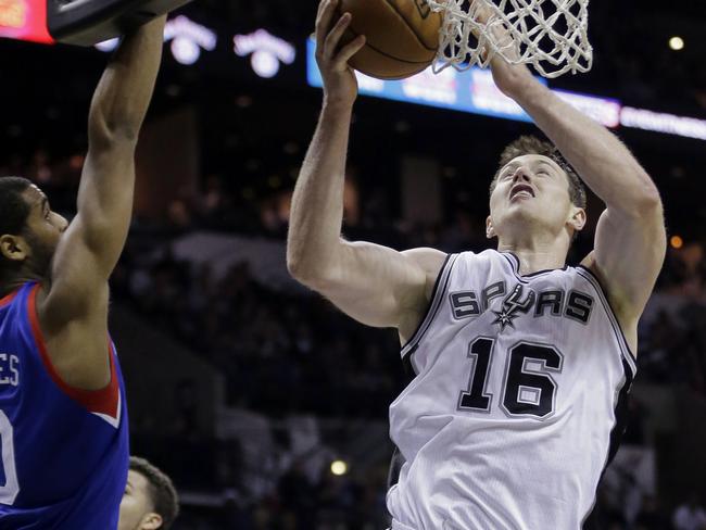 San Antonio Spurs' Aron Baynes (16) shoots past Philadelphia 76ers' Brandon Davies (0) during the first half of an NBA basketball game, Monday, Nov. 17, 2014, in San Antonio, Texas. (AP Photo/Eric Gay)