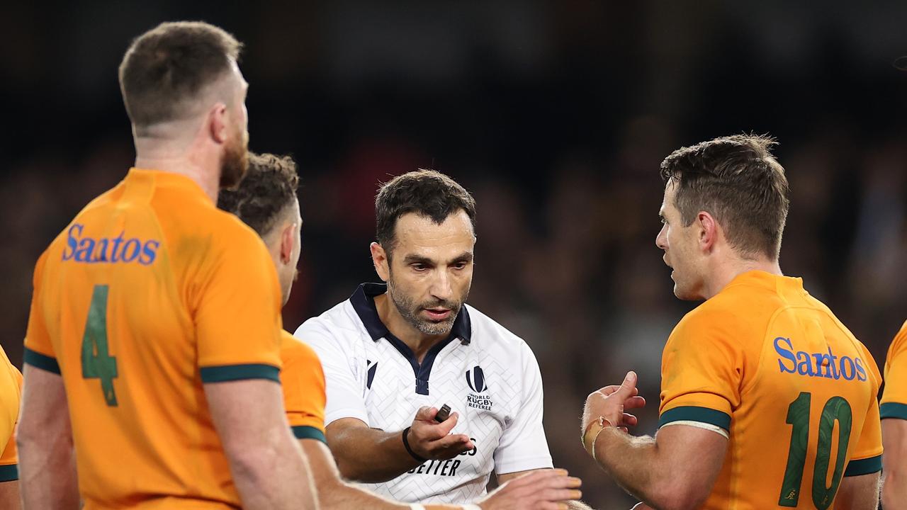 Referee Mathieu Raynal speaks to Nic White and Bernard Foley of the Wallabies after awarding a free kick to the All Blacks at Marvel Stadium. Photo: Getty Images