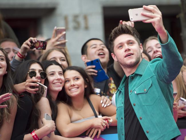 Niall Horan takes a selfie with fans. Picture: Nathan Denette/The Canadian Press via AP