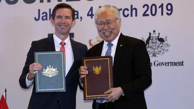 Australia Trade Minister Simon Birmingham, left, and Indonesia Trade Minister Enggartiasto Lukita pose for photographers during a signing ceremony and business forum in Jakarta, Indonesia, Monday, March 4, 2019. Indonesia and Australia are signing a free trade agreement that will eliminate many tariffs, allow Australian-owned hospitals to be set up in the giant Southeast Asian country and increase work visas for young Indonesians. (AP Photo/Achmad Ibrahim)