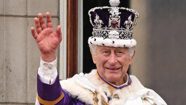 TOPSHOT - -- AFP PICTURES OF THE YEAR 2023 --  Britain's King Charles III wearing the Imperial state Crown, and Britain's Queen Camilla wearing a modified version of Queen Mary's Crown wave from the Buckingham Palace balcony after viewing the Royal Air Force fly-past in central London on May 6, 2023, after their coronations.. The set-piece coronation is the first in Britain in 70 years, and only the second in history to be televised. Charles will be the 40th reigning monarch to be crowned at the central London church since King William I in 1066. (Photo by Oli SCARFF / AFP) / AFP PICTURES OF THE YEAR 2023