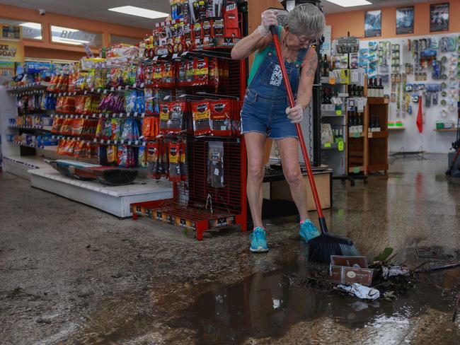 A worker sweeps the water and mud from inside a Florida supermarket after it was inundated with flood water when Hurricane Milton passed through. Picture: Getty Images via AFP