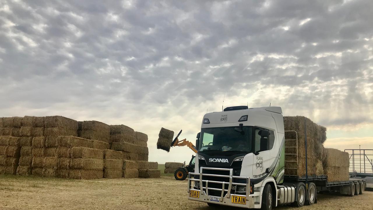 Hay bales being unloaded from contractor and volunteer Michael Hancock's truck as part of Rural Aid's drought relief operation. Picture: supplied