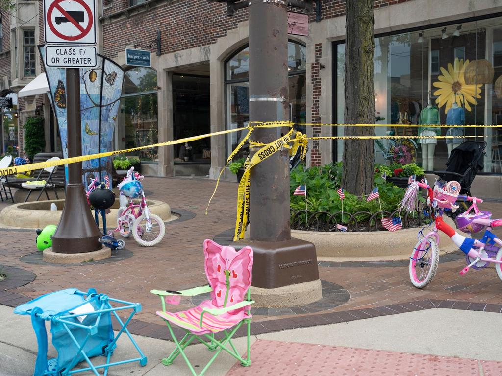 Police crime tape is seen around the area where children's bicycles and baby strollers stand near the scene of the shooting in Highland Park. (Photo by Youngrae Kim / AFP)