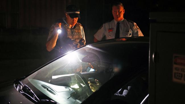 Sergeant Simon Telfer and Detective Inspector Evans speak to the driver of a car they pulled over during their search for weapons. Picture: Richard Dobson