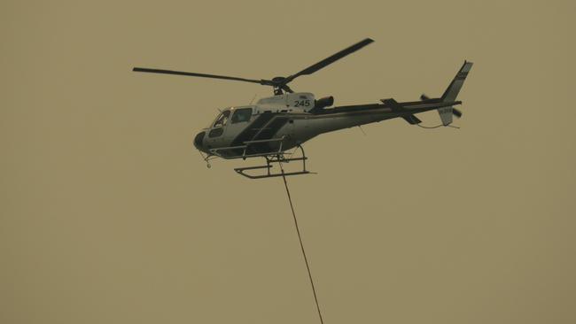 Three mile fire: Water bombing helicopter flies overhead at the Three Mile bushfire near Mangrove Creek.