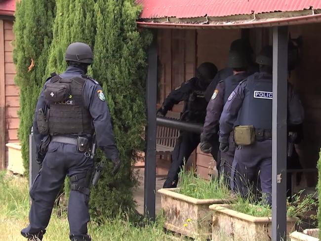 Raid... Specialist officers raid the vacant property at Oberon. Picture: NSW Police