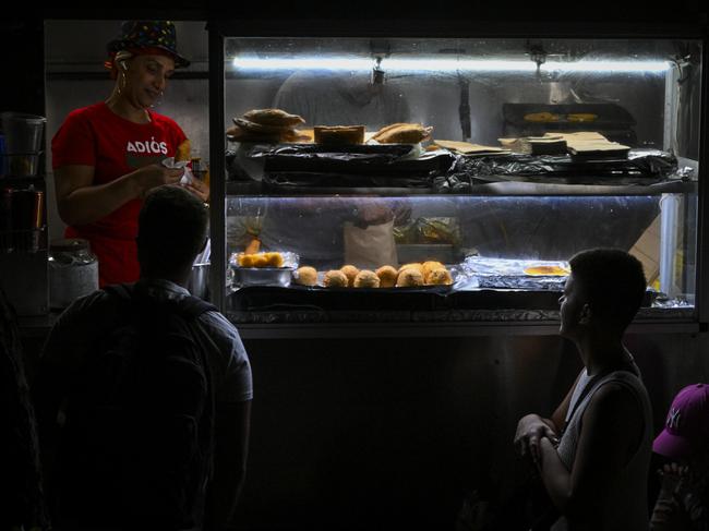 SAN JUAN, PUERTO RICO - DECEMBER 31: People in the line wait food on a dark street on December 31, 2024 in San Juan, Puerto Rico. The majority of the population on the island is without electricity due to a major power outage. (Photo by Miguel J. Rodriguez Carrillo/Getty Images)