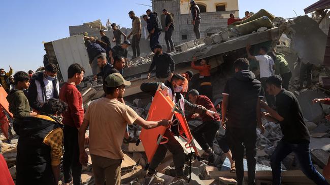 A Palestinian medic walks among civilians on the rubble of a building after an Israeli strike on Rafah, in the southern Gaza Strip on November 23. Picture: Said Khatib/AFP