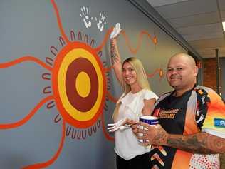 PAYING RESPECT: Sarah Peterson and artist Lionel Cubby at BEST employment in front of their new mural. Picture: Meg Bolton