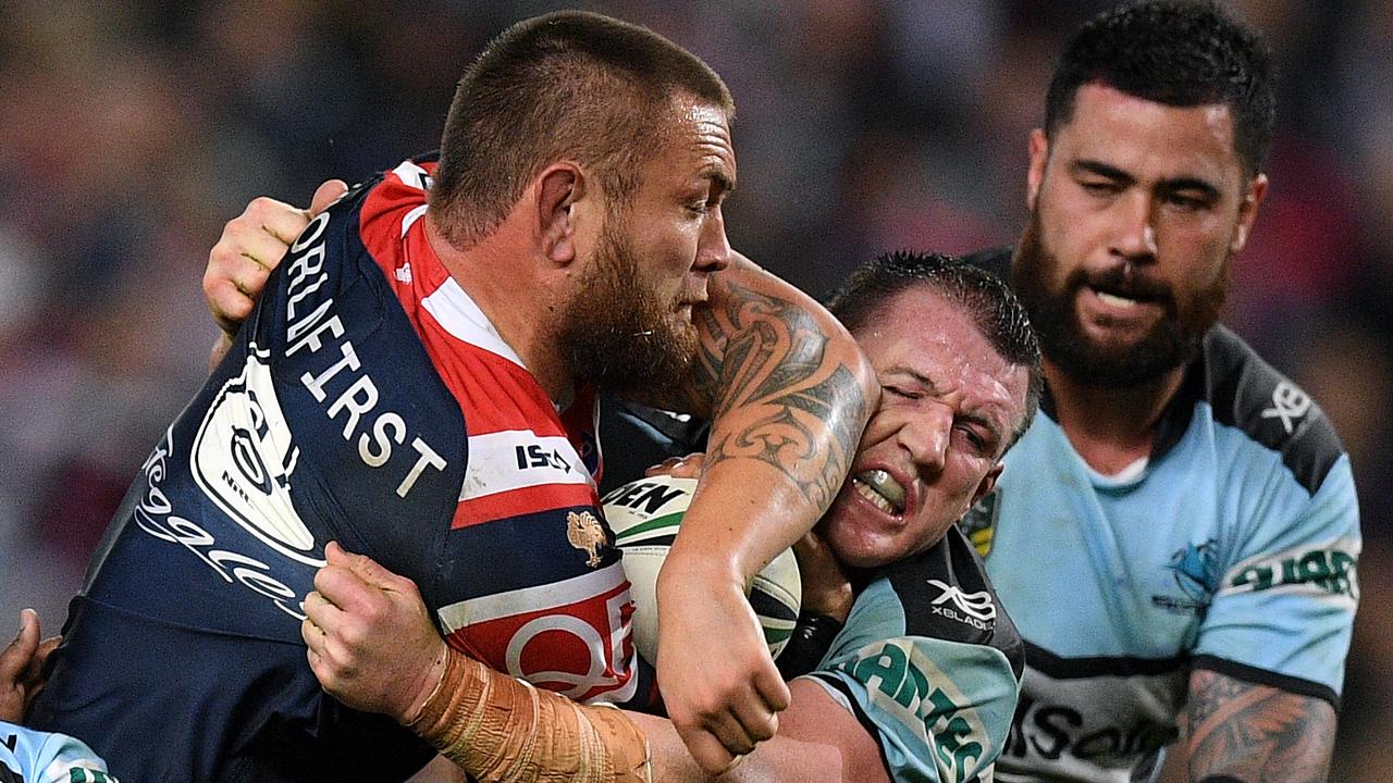 Jared Waerea-Hargreaves of the Roosters is tackled by of the Sharks 