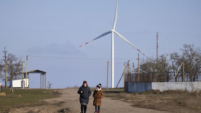 Local residents walk to the main road of a village near a large wind turbine park in Hirsivka, Ukraine. Picture: Pierre Crom/Getty Images