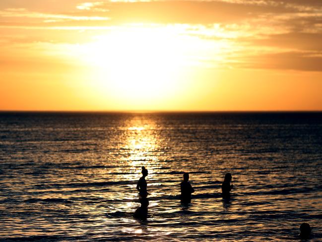 Beachgoers during hot weather at Glenelg Beach in Adelaide, Wednesday, December 18, 2019. A record-breaking heatwave is making its way across southeastern Australia, with temperatures set to exceed 40C in many parts of the country. (AAP Image/Kelly Barnes) NO ARCHIVING