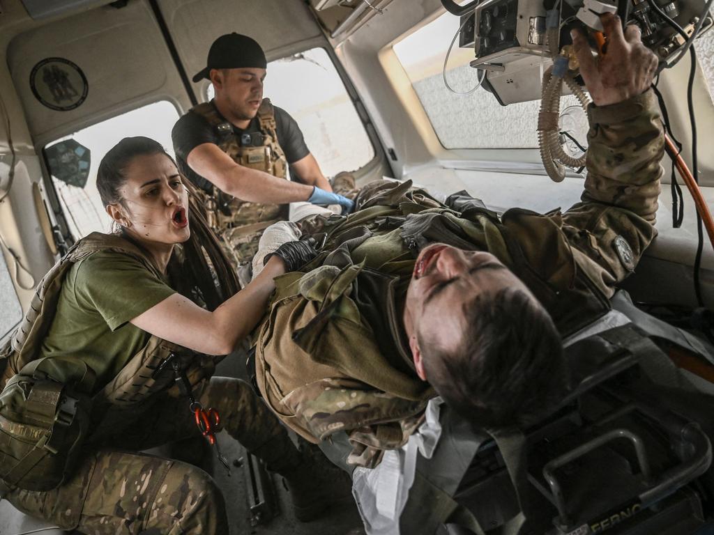 Ukrainian military paramedics evacuate a wounded serviceman from the frontline. Picture: AFP