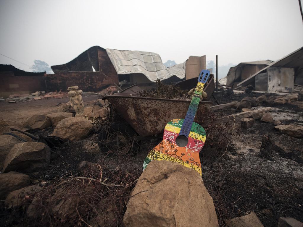 The morning after a devastating blaze destroyed homes and businesses in the small town of Cobargo. The town has been decimated by fire. An unburnt guitar sits out the front of a destroyed property. Picture Gary Ramage