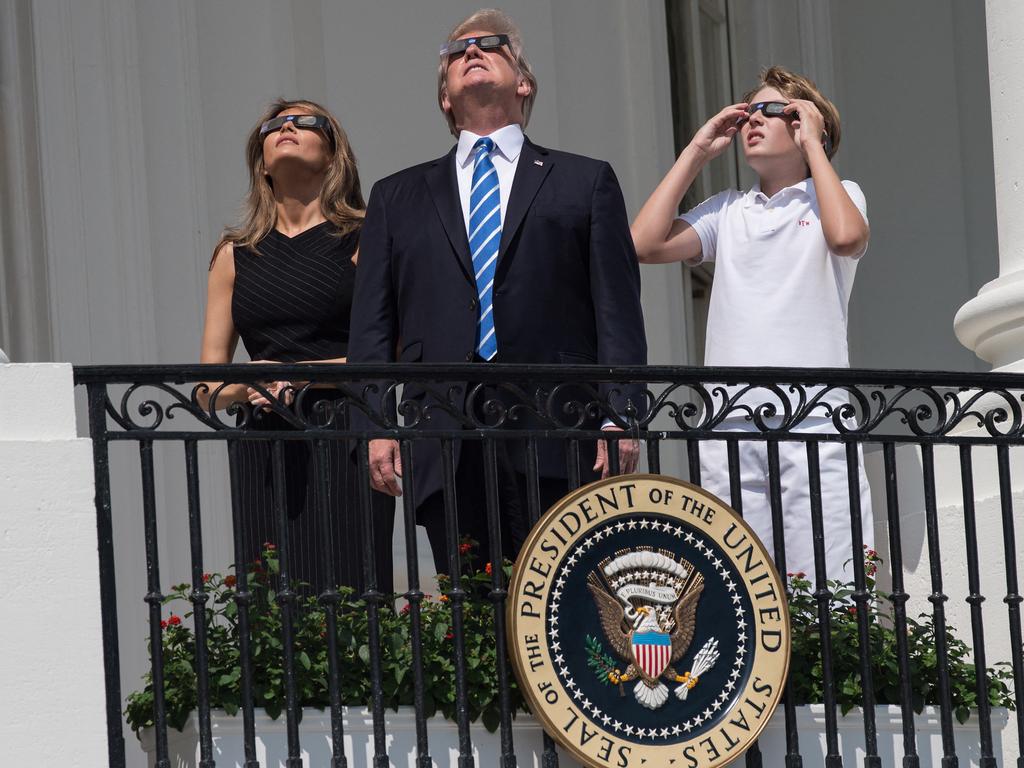 Former US President Donald Trump, First Lady Melania Trump and son Barron look up at the partial solar eclipse from the balcony of the White House in Washington, DC. Picture: AFP