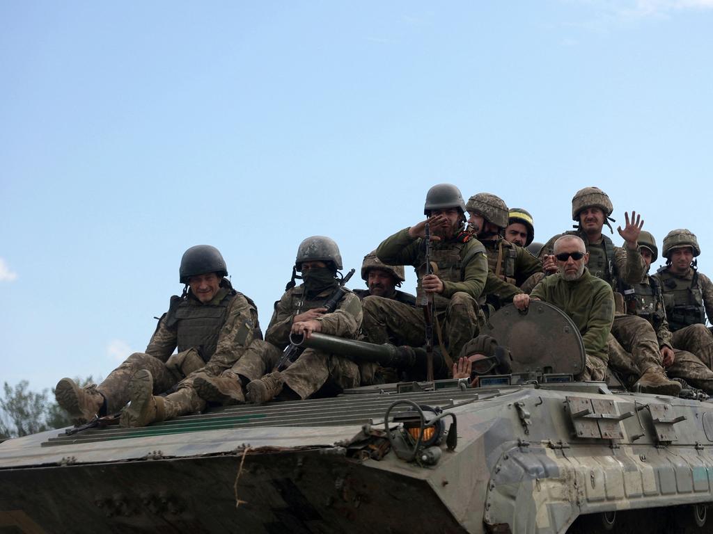 Ukrainian soldiers ride on an armoured personnel carrier (APC) on a road of the eastern Luhansk region. Picture: AFP