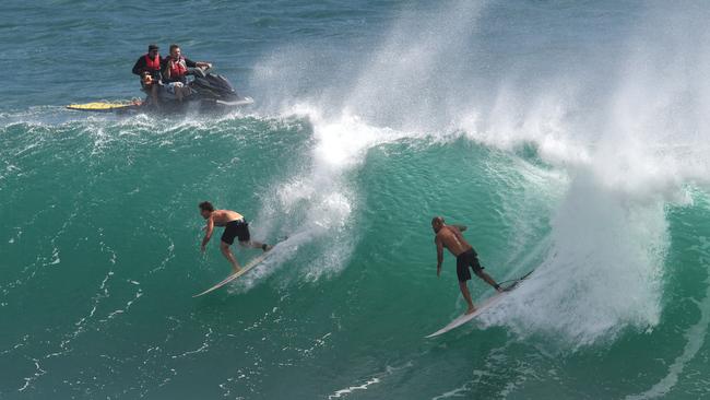 Surfers are seen riding waves at Kirra on the Gold Coast, Saturday, February 23, 2019. Huge swells and high tides are pummelling southeast Queensland beaches as Cyclone Oma sits off the Queensland coast. (AAP Image/Darren England)