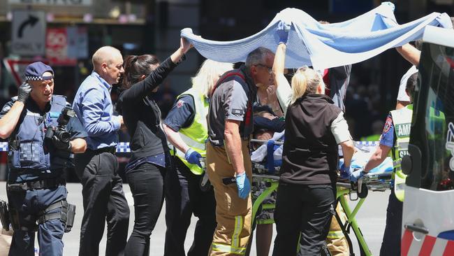 A victim is taken to an ambulance. Picture: David Crosling