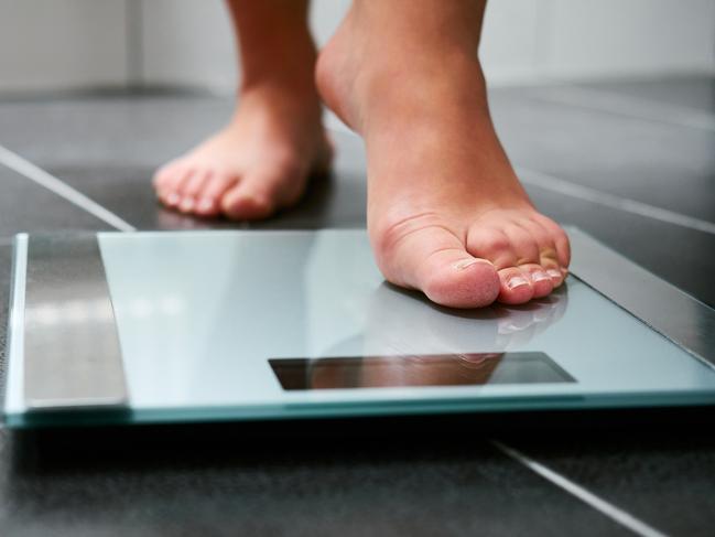 Female bare feet with weight scale in the bathroom, scales generic