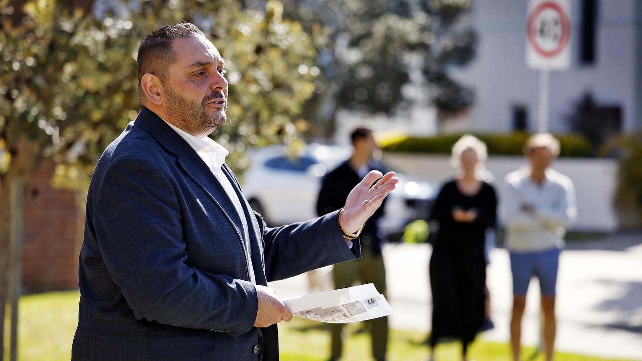 Auctioneer Matthew Shalhoub at Saturday’s auction, with the eventual purchasers in the background. Picture: Sam Ruttyn