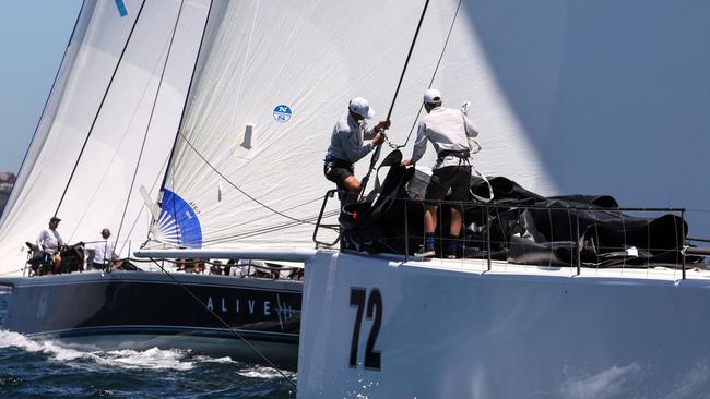 Crew aboard the yachts Alive and URM in a race on Sydney Harbour.