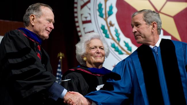 US President George W. Bush shakes hands with his father, former President George H.W. Bush alongside his mother, former First Lady Barbara Bush in 2008.