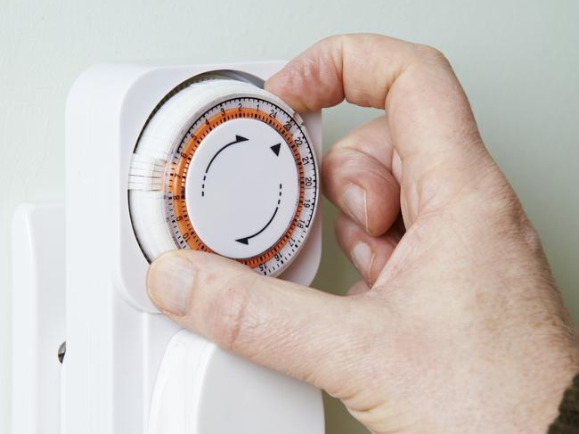 Man Adjusting Timer On Electrical Socket