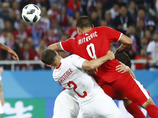 Serbia's Sergej Milinkovic-Savic, left, heads the ball as Serbia's Aleksandar Mitrovic and Switzerland's Stephan Lichtsteiner challenge during the group E match between Switzerland and Serbia at the 2018 soccer World Cup in the Kaliningrad Stadium in Kaliningrad, Russia, Friday, June 22, 2018. (AP Photo/Matthias Schrader)