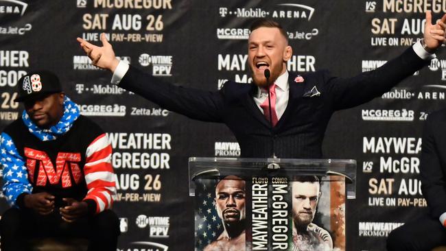 Floyd Mayweather Jr. looks on as UFC fighter Conor McGregor speaks about their upcoming fight.