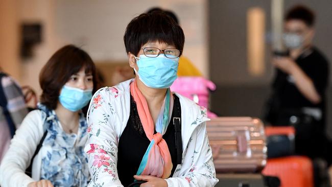 Travellers at Brisbane International Airport wearing masks as a precaution this week. Picture: AAP Image/Darren England