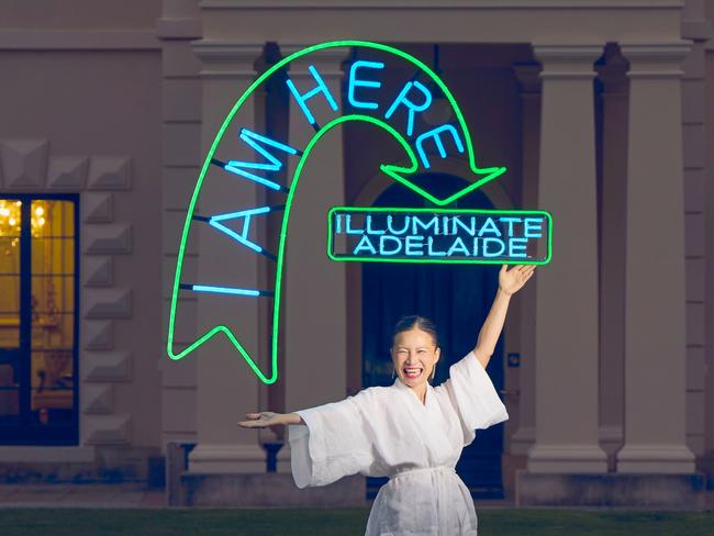 Celebrity chef and visual artist Poh Ling Yeow outside Government House, Adelaide, with Illuminate Adelaide festival neon sign. Picture: Matt Loxton, supplied