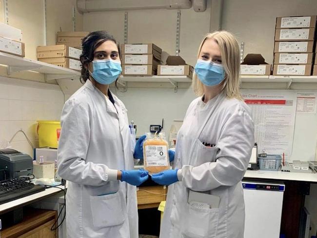 Hannah Brophy, of Ashgrove, Brisbane, at work in Manchester, UK, with the first packet of convalescent plasma used to treat coronavirus cases. She has received a coronavirus jab and encouraged people in Australia to take it when it becomes available.