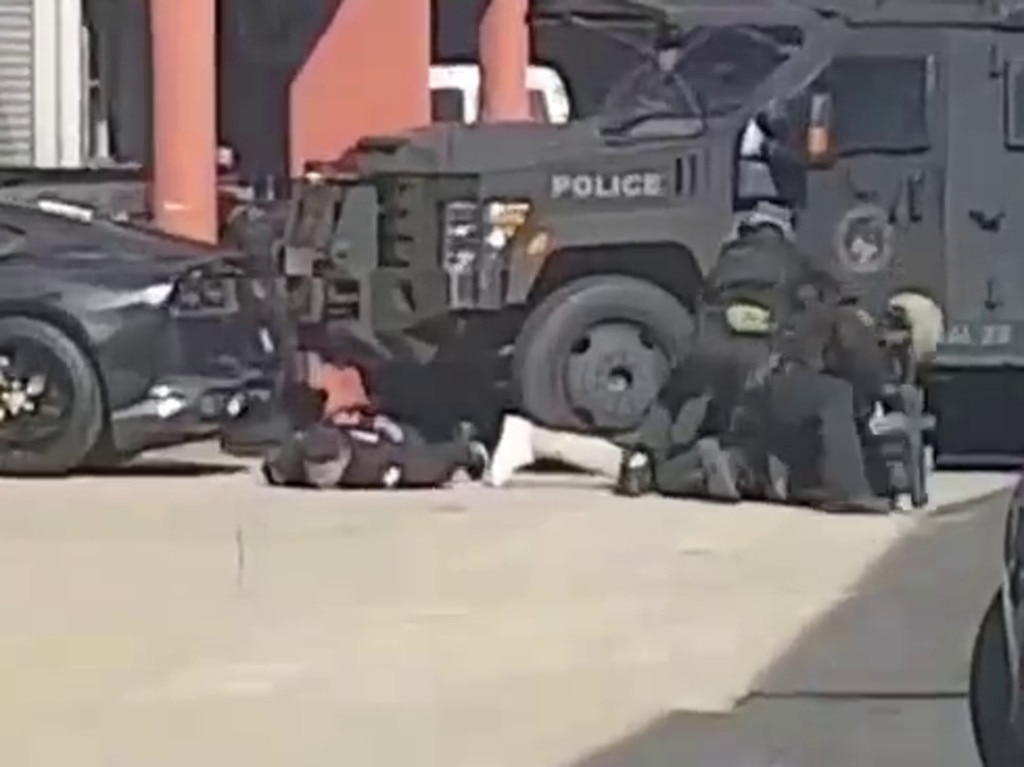 Tactical police arresting the men.