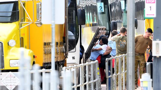 AUSMAT staff hug members of the first Howard Springs group of evacuees as they depart the camp last week after successfully completing their quarantine period. Picture: Che Chorley