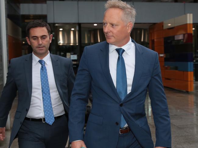 Sam Henderson (right) leaves the royal commission after giving evidence as ABC reporter Danny Ziffer peppers him with questions. Picture: Stefan Postles