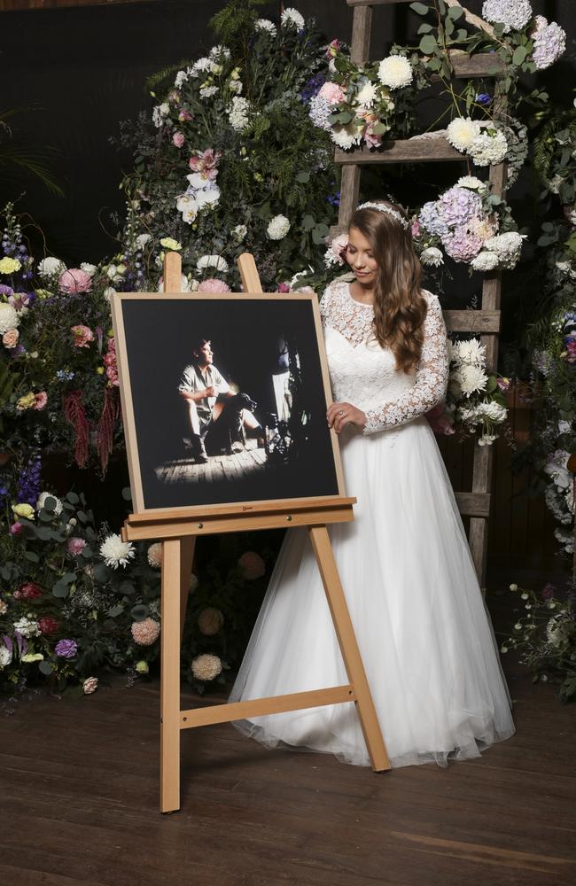 Bindi Irwin standing next to an easel with a photo of her father Steve. Picture: Kate Berry