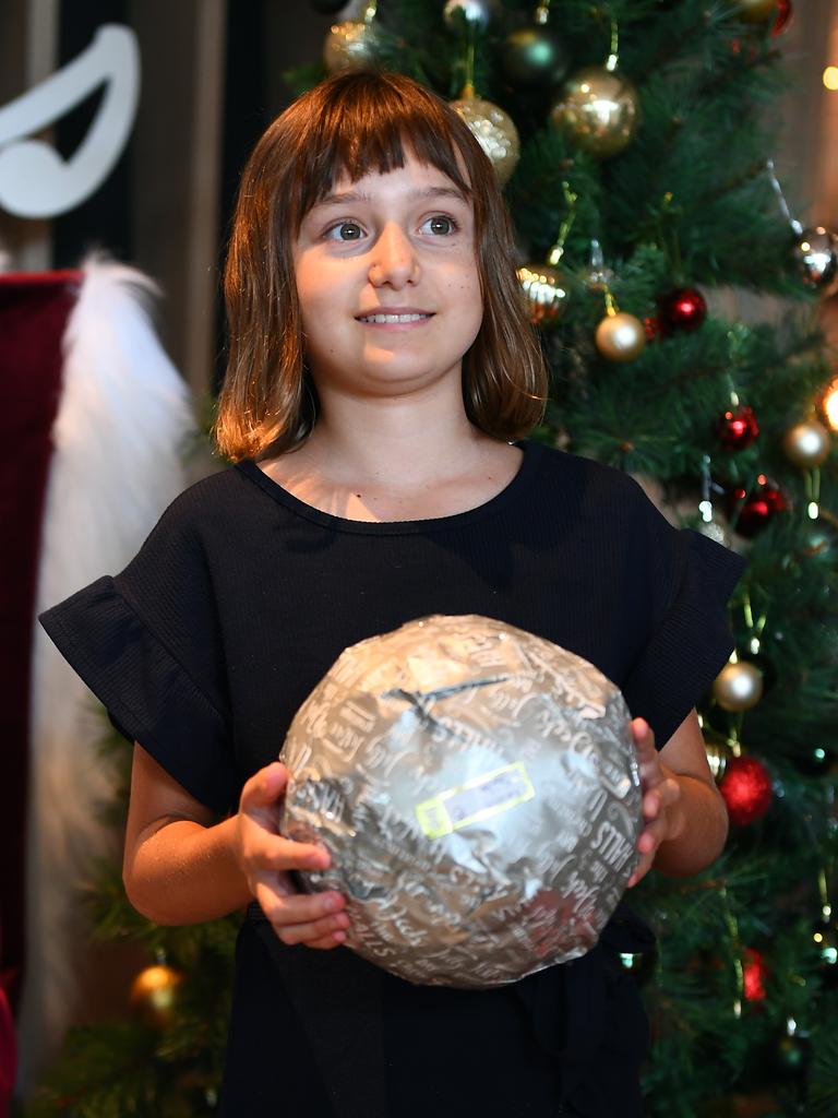 Caitlin Wray receives a gift from Santa at Silks, Darwin. Picture: (A)manda Parkinson